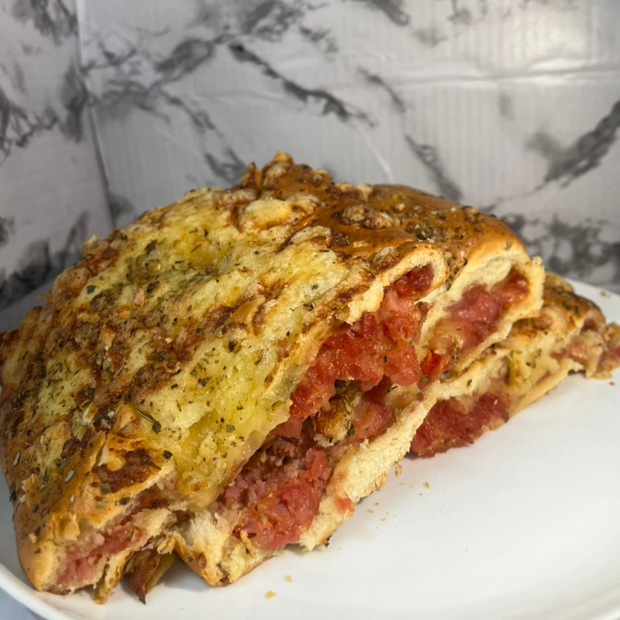 Pão pizza assado, macio por dentro e com crosta dourada de parmesão por fora, coberto com presunto, queijo derretido, tomate fresquinho, catupiry cremoso e um toque de orégano aromático. O sabor da pizza em versão de padaria, quentinho, reconfortante e simplesmente irresistível!