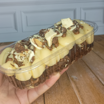 Pedaços de brownie afogados no recheio cremoso de leite em pó, pedaços de bombom ouro branco e creme de avelã. Peso final Aprox. 200g.