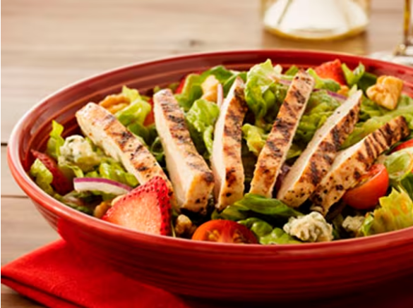 Frango grelhado, alface-romana, morangos frescos, cebola roxa, nozes, tomates e notas de queijo tipo gorgonzola. Servida ao molho vinagrete de morangos do Abbraccio.