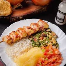 Acompanha, arroz, feijão tropeiro, mandioca, vinagrete e espetinho de frango com bacon.