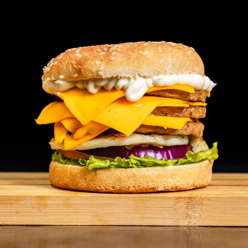 Pão, 3 Carnes Padrão. Queijo Cheddar, Salada, Tomate, Cebola ,Ovo, Cream Cheese e Molho da casa.