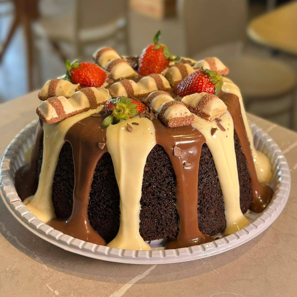 BOLO VULCÃO COM MASSA DE CHOCOLATE , COBERTURA MESCLADA DE NINHO E NUTELLA , COM CHOCOLATE KINDER BUENO E MORANGOS NO TOPO