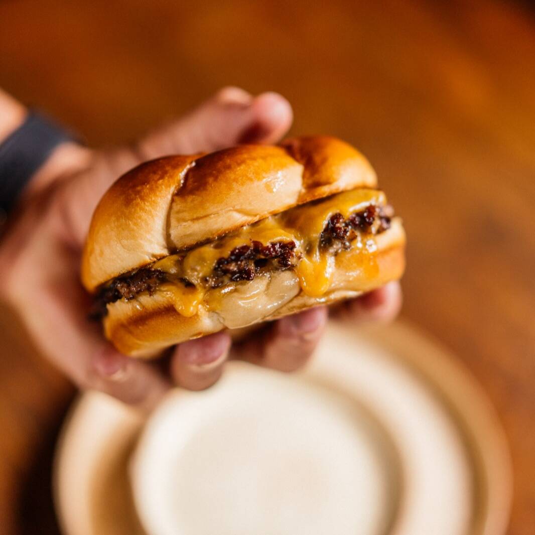 Hambúrguer de 120 grs Esmagado na Chapa / American Cheese / Cebola em Cubos / Pickles em Fatias / Catchup / Finalizado em Nosso Exclusivo Pão de Brioche Raw / Atenção Item Servido Apenas Bem Passado.