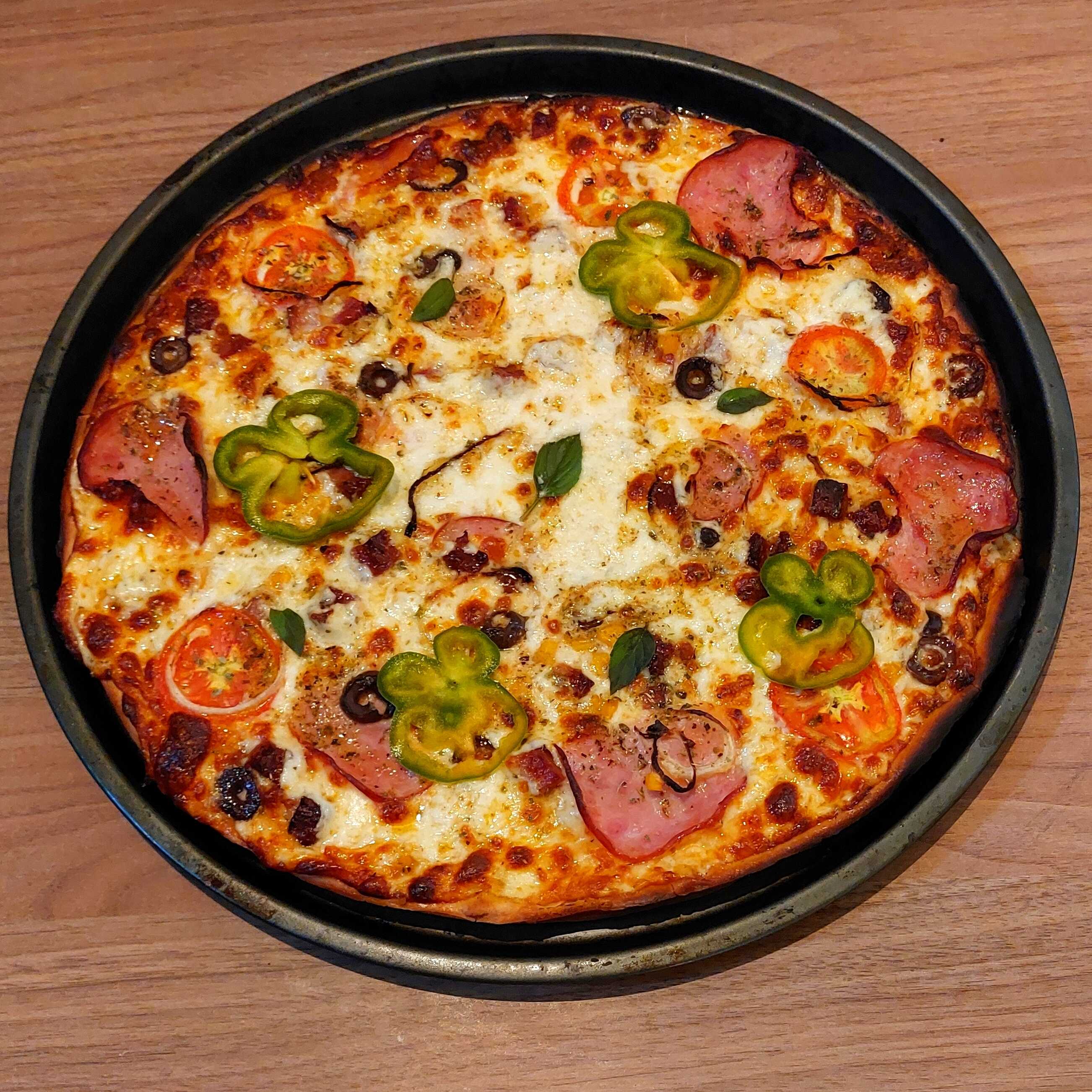 Incrível e deliciosa Pizza À Moda da Cheff, com Molho de Tomate Artesanal da casa, Queijo Mussarela, Lombo Canadense, Presunto, Bacon, rodelas de Tomates frescos, Pimentão, Cebola, Azeitonas Pretas, Catupiry, Milho e Finalizada com Orégano.