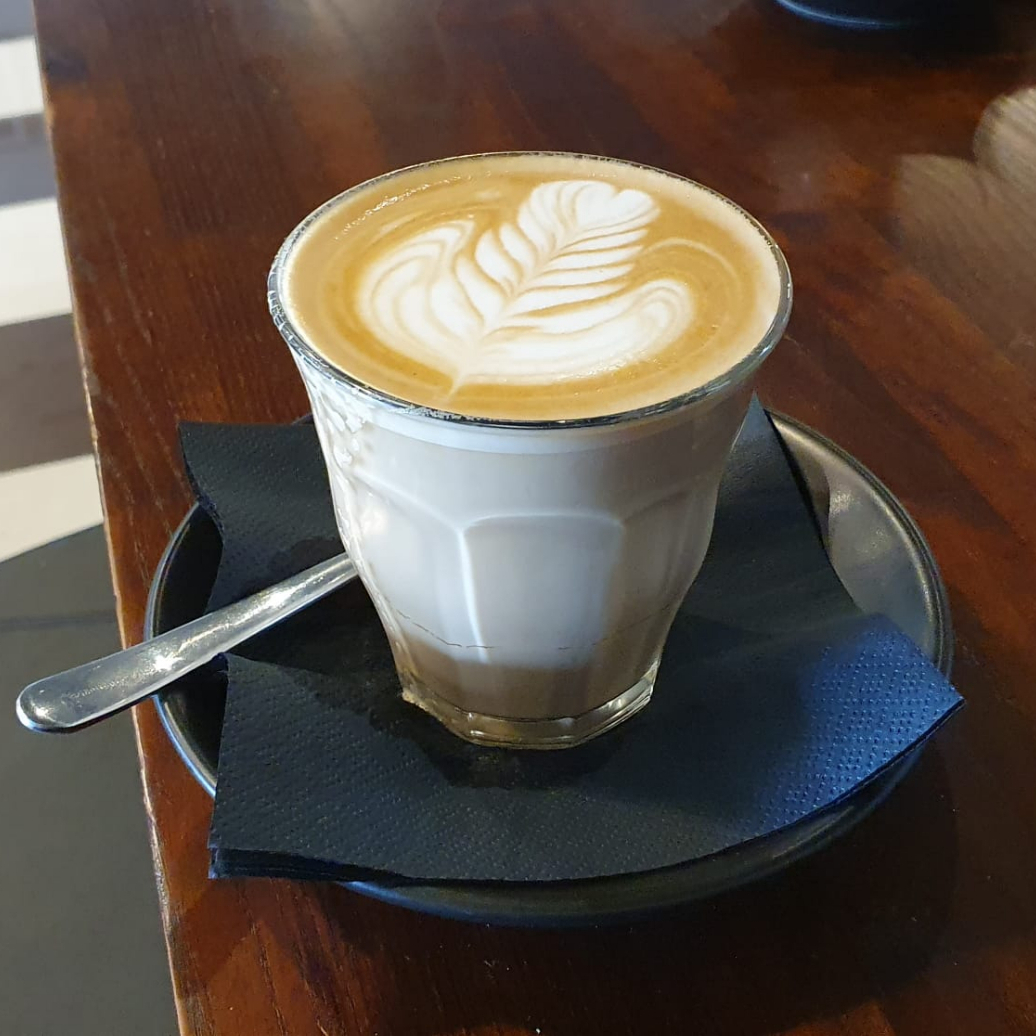 Uma dose de café espresso e leite vaporizado com crema de leite.