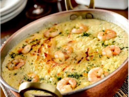 Arroz de leite coberto com camarões refogados em cheiro-verde, cebola, alho, tomate fresco e nata. O prato é gratinado e acompanha macaxeira frita.tamanho do camarão nesse prato: 18g.