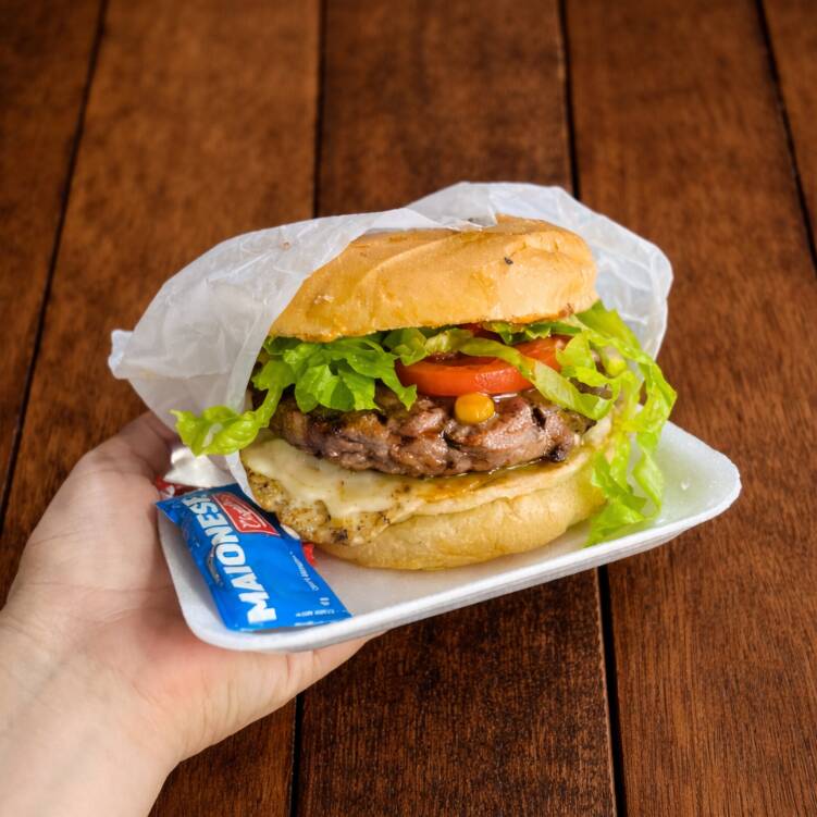 Pão de hambúrguer, 1 hambúrguer, alface, tomate, milho, ovo, maionese e batata palha.