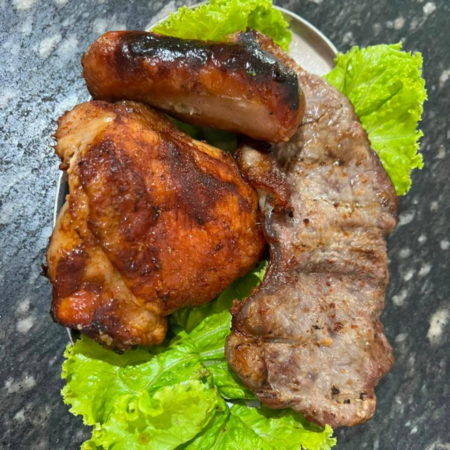 1 fatia de filé especial, 1 coxa de frango e 1 toscana. Acompanhamentos: farofa e salada vinagrete.