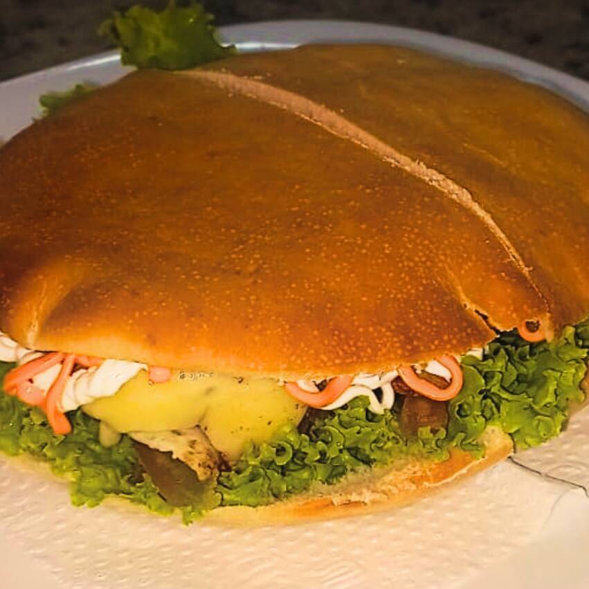 Um sanduíche leve, feito por ovo, alface, tomate, muçarela, Catupiry, cheddar e hambúrguer de carne, tudo entre pão sírio.