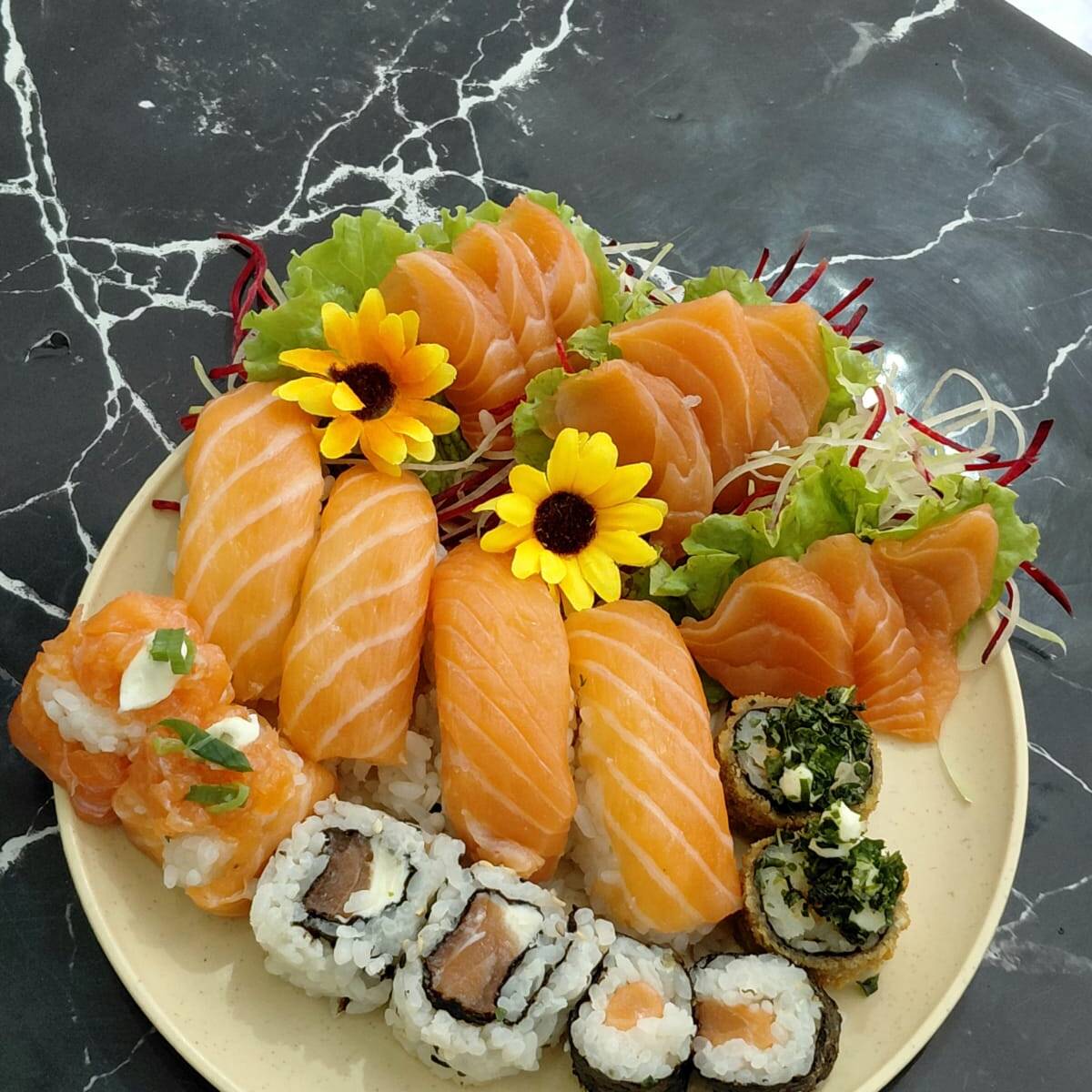 9 sashimis de salmão, 4 niguiris de salmão, 2 jhous de salmão, 2 uramaki de salmão, 2 hossomaki de salmão e 2 hot roll com couve. Acompanha 2 hashis, 2 saches de molho shoyo e 2 saches de tarê.