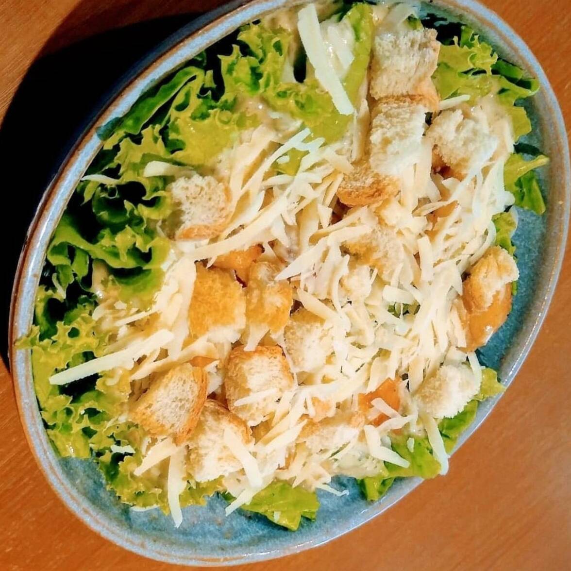 Alface, frango grelhado, parmesão, croutons e molho caesar.