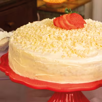Um bolo super famoso e perfeito para sua festa ou comemoração! Massa leve, recheado de leitinho com preparado de morango e coberto por granulados macios de chocolate branco.