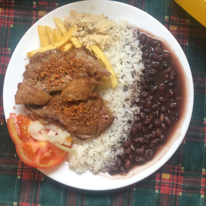 Delicie-se com nosso prato completo, acompanhado de arroz soltinho, feijão temperado na medida, farofa crocante, batata frita dourada e uma fresca salada de alface, tomate e cebola.