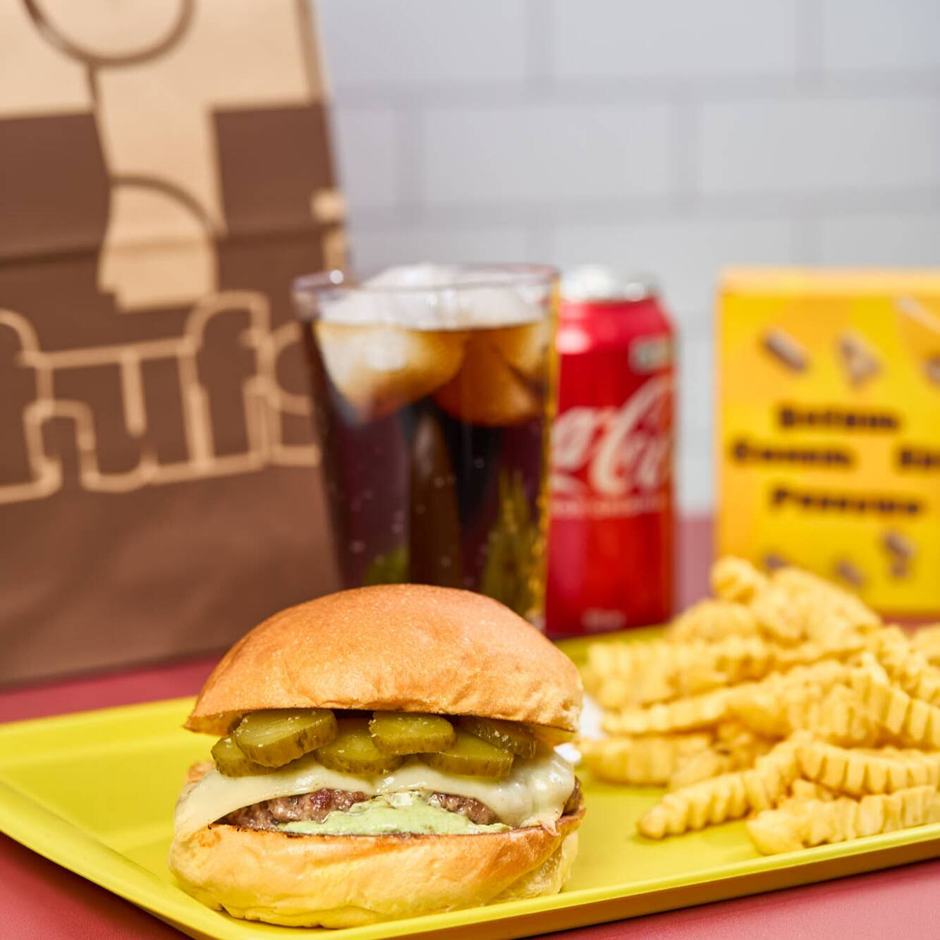 Pão de brioche, maionese verde, smash burguer amassado na chapa com cebola, mussarela e picles. Acompanha bebida e batata frita.