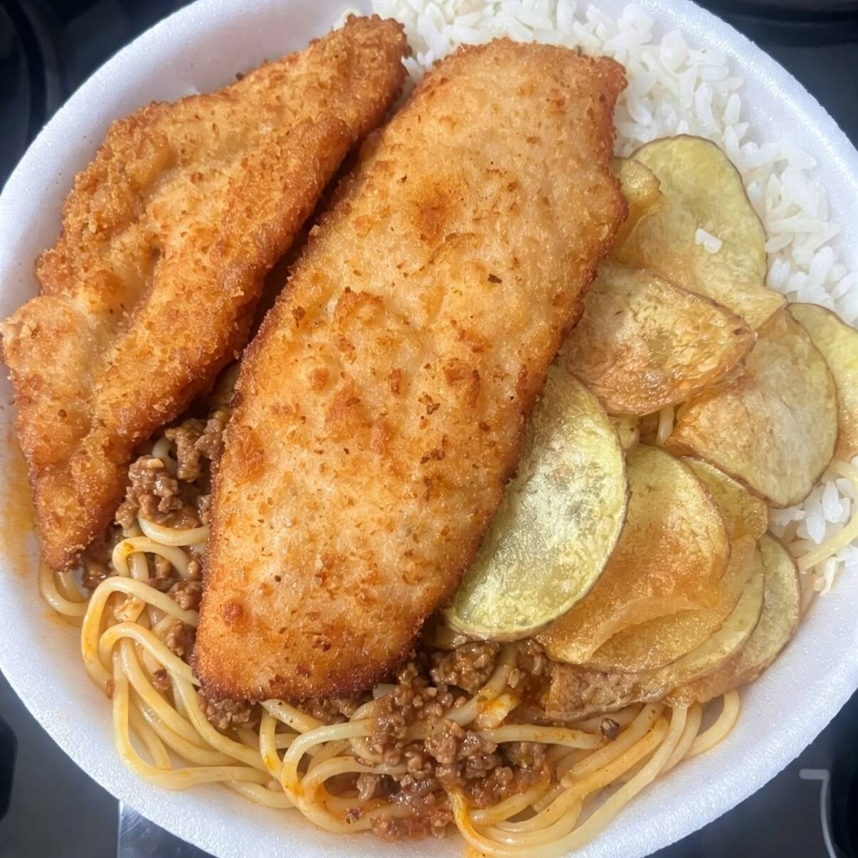 Arroz, feijão, macarrão, filé de frango empanado e batata frita.