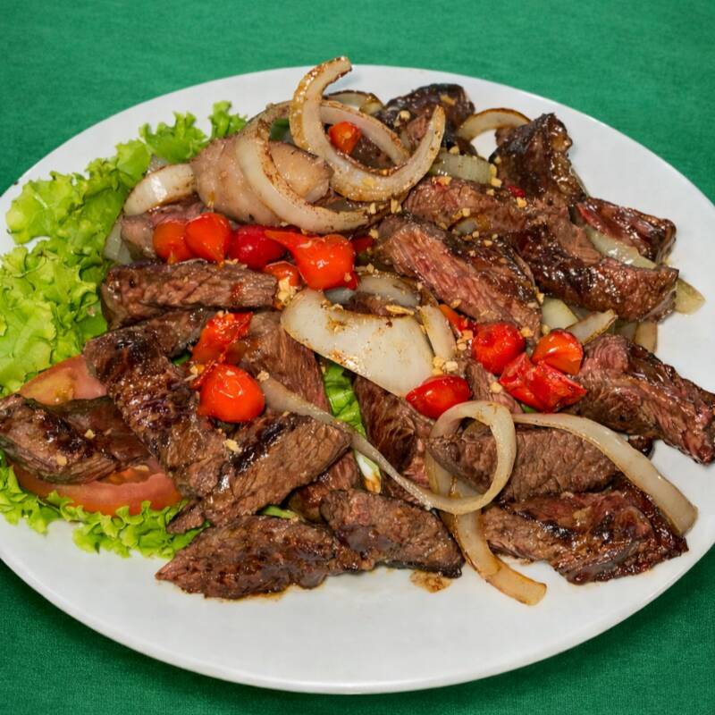 Picanha fatiada, grelhada e servida com cebolas douradas. Sabor intenso e maciez garantida.