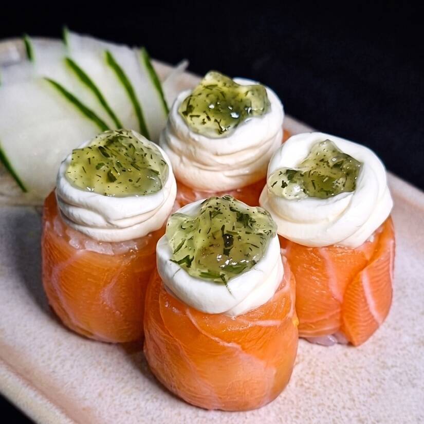 Enrolado de salmão com arroz, cream cheese finalizado com geléia de hortelã.