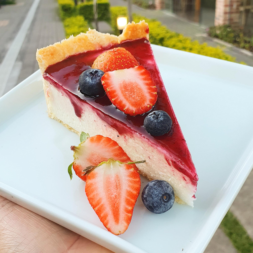 Cheesecake cremosa com base de biscoito e cobertura de calda de frutas vermelhas. Doce na medida e com toque leve de acidez. Perfeita!