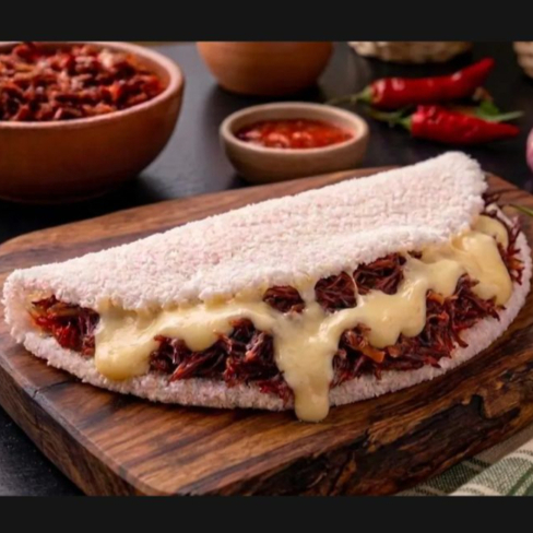 Massa de Tapioca recheada com mussarela e carne seca desfiada, temperada com alho e cebola