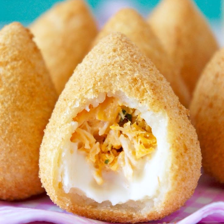 Coxinha recheada de frango desfiado com um toque cremoso de requeijão, perfeita para amantes de sabores suaves.