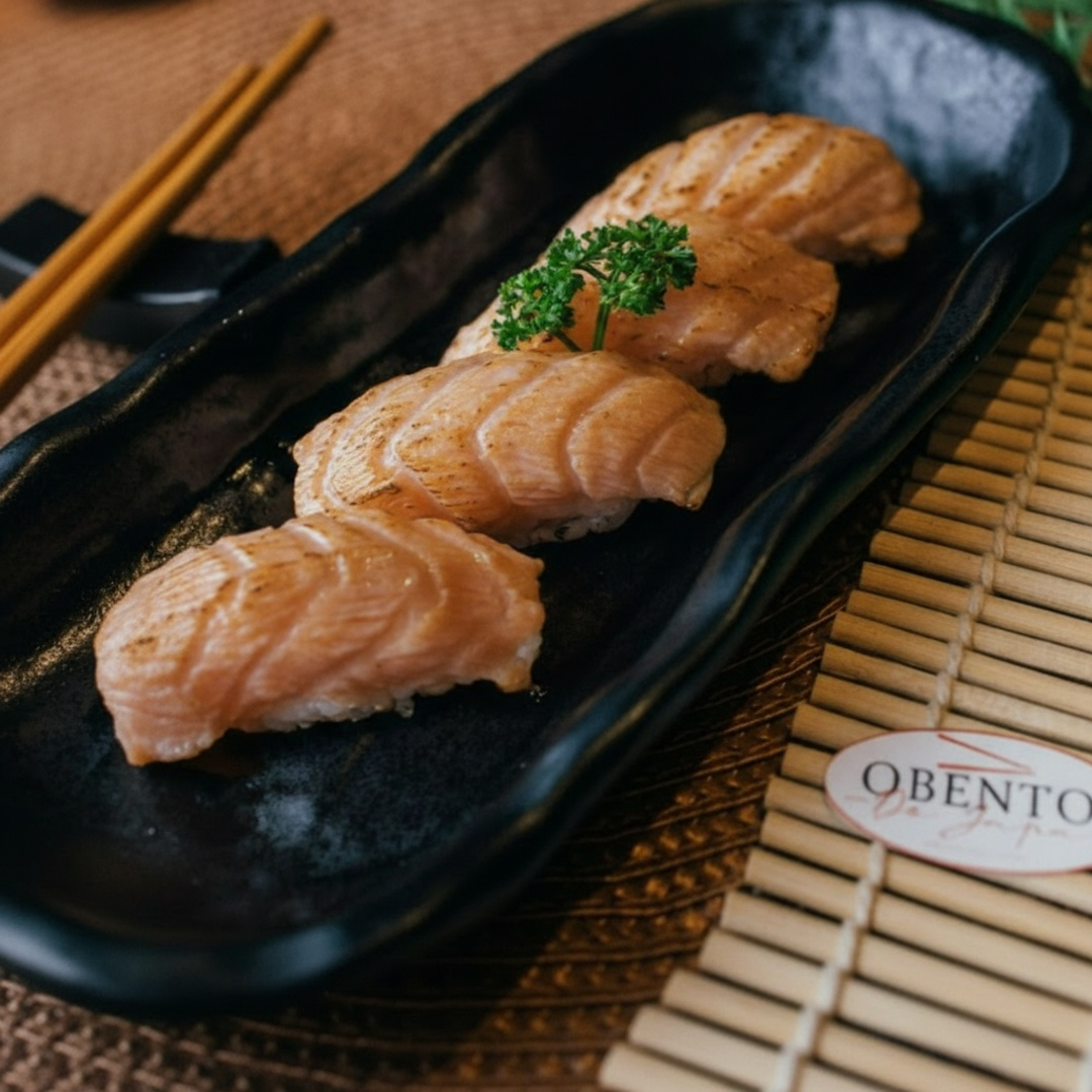 O nigiri de salmão é um tipo de sushi que consiste em uma pequena porção de arroz temperado, moldado em formato oval, e coberto com uma fatia de salmão massaricado.
