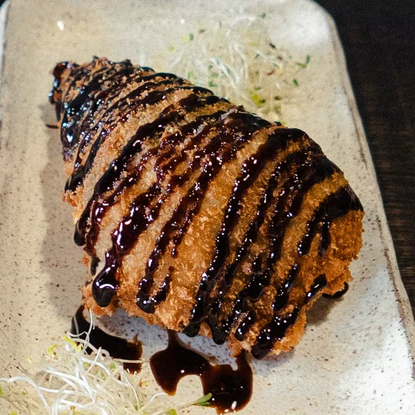 Cone crocante com recheio quente de alho-poró e creme de castanha de caju finalizado com tarê.