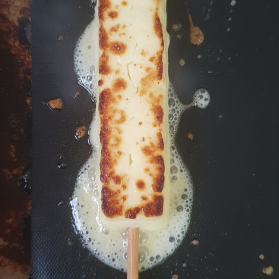 Queijo coalho levemente grelhado no espeto, perfeito para acompanhar uma cerveja gelada.
