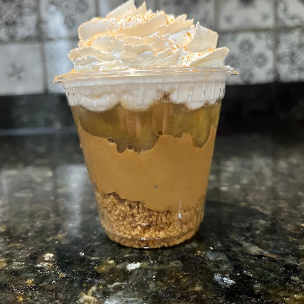 Farofinha de biscoito maisena, doce de leite, banana caramelizada, chantilly e uma pitada de canela.