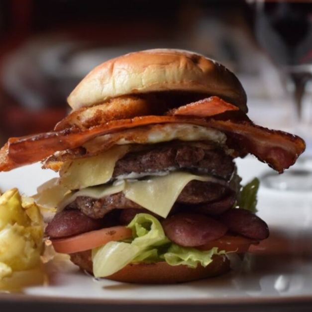 Pão tostado, blend artesanal 130g, queijo mussarela, ovo, maionese da casa, bacon, calabresa, alface, tomate, pepino, anéis de cebola.
