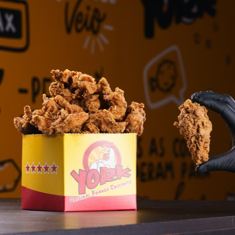 Balde Box Coxinha da Asa 450g, empanado em temperos artesanais e frito em alta temperatura, garantindo suculência interna e crocância externa. Acompanha molho enviado separadamente. Peso de 450 gramas, ideal para até 2 pessoas. *Foto apenas ilustrativa, confira o peso na descrição