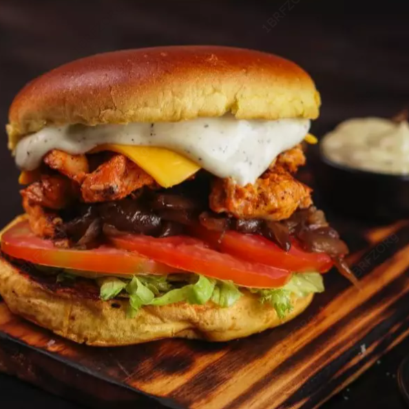 Pão bola, deliciosa carne artesanal tostada na chapa, 1x porção de frango, queijo cheddar derretido em cima da carne, alface fresquinho do Dia , tomate salada, cebola caramelizada ao shoyo, e por fim 1x camada de maionese cremosa artesanal.