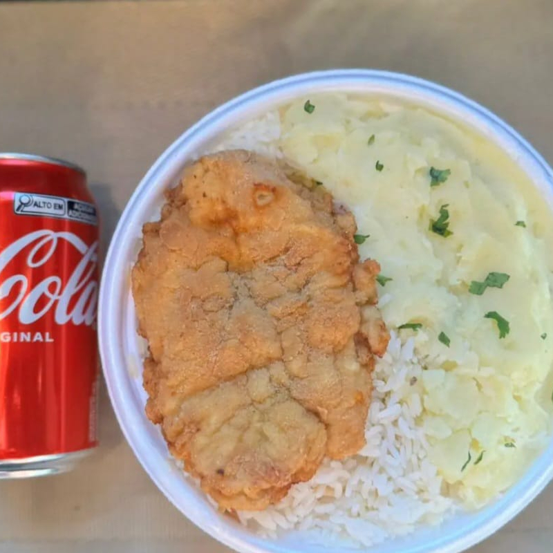Marmita com delicioso filé de frango empanado na massa crocante acompanhado de arroz branco, feijão e purê batata. Acompanha refrigerante lata Coca Cola 350ml, marmita indicada para 01 pessoa.