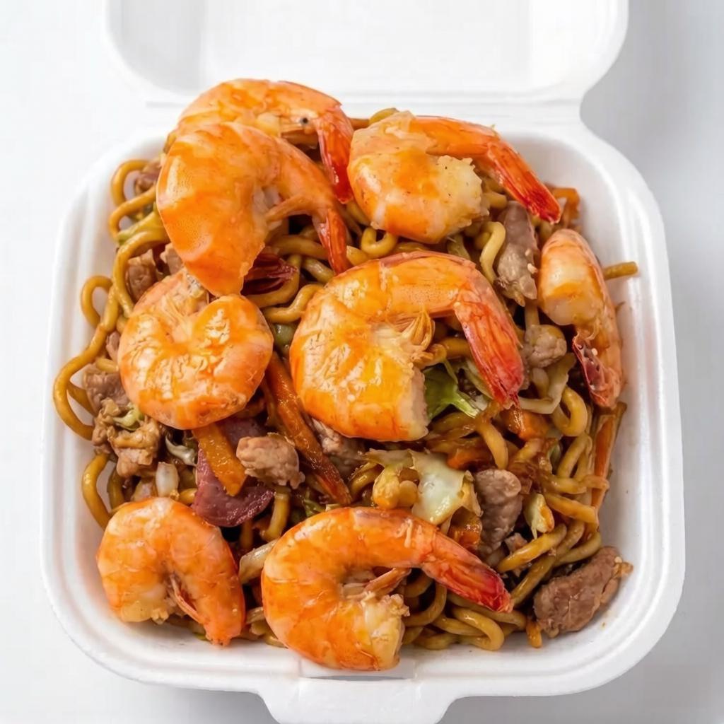 Nosso Yakissoba de Camarão é uma verdadeira sinfonia de sabores. Um prato exuberante que combina camarões frescos e suculentos com uma seleção primorosa de legumes crocantes e coloridos. Possui cebola, repolho branco, repolho roxo e cenoura cuidadosamente cortados e salteados. Tudo isso envolvido em molho de yakissoba tradicional que realça o sabor de cada ingrediente. Um prato delicioso e saudável, perfeito para quem aprecia a culinária oriental.