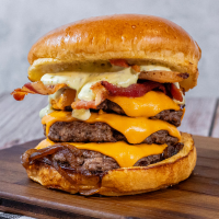 Pão brioche, 3 smash burguer, 3 camada de queijo cheddar, cebola caramelizada e fatias de bacon