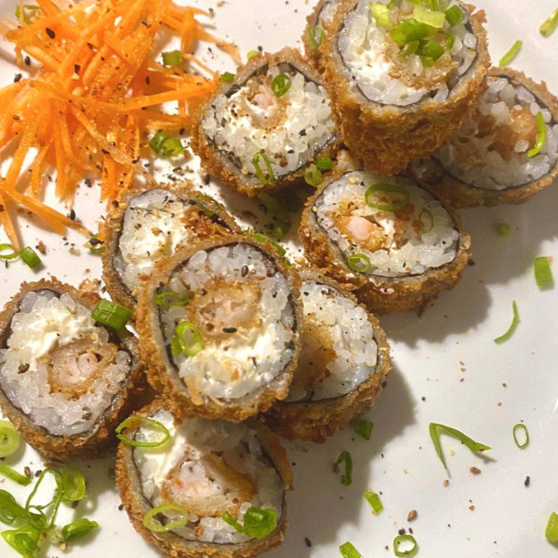 Arroz, cream cheese e camarões enrolados em folha de nori, empanados e fritos.