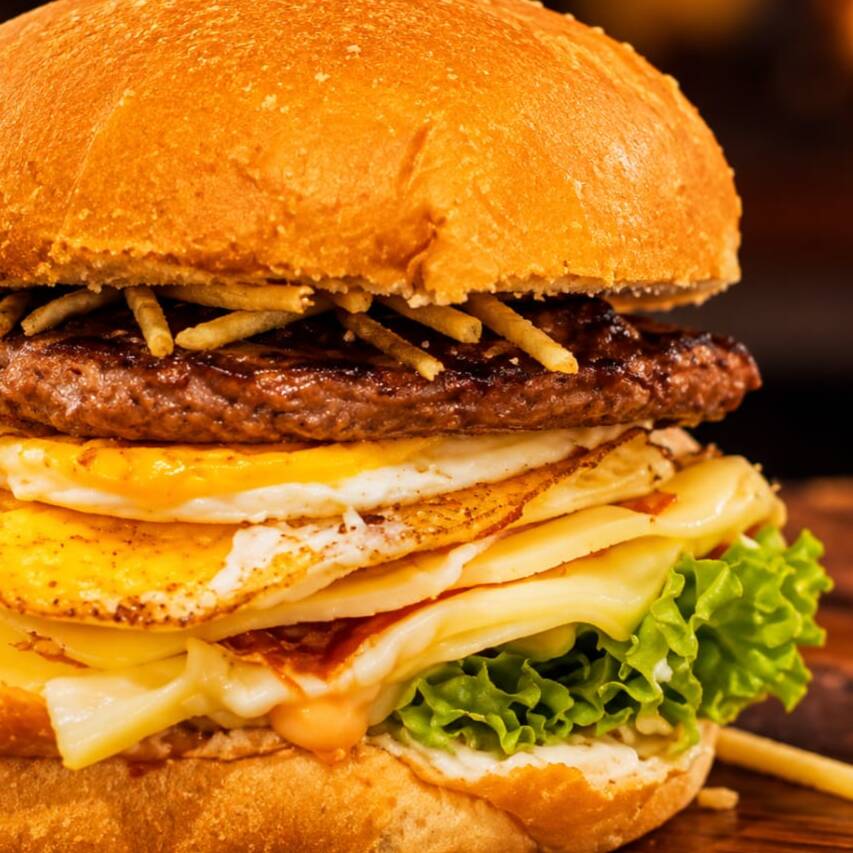 Hambúrguer suculento 90g com ovo frito na hora, presunto e queijo derretido, acompanhado de batata palha crocante, milho, alface fresca e tomate. Finalizado com ketchup e maionese para entregar cremosidade, crocância e muito sabor em cada mordida.
foto ilustrativa