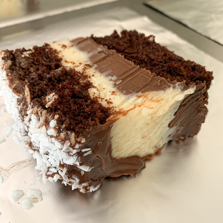 Massa de cacau, com calda de chocolate, cocada cremosa e trufa de chocolate. Aprox 150g