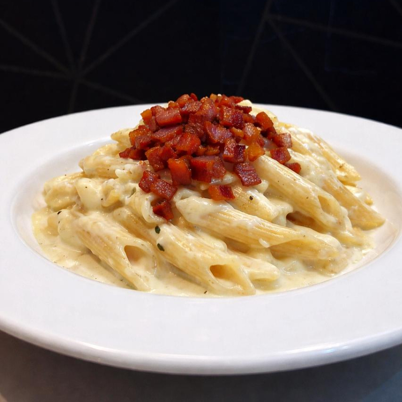 Penne al dente, cubos de bacon crocante, e molho branco especial da Dotrigo.