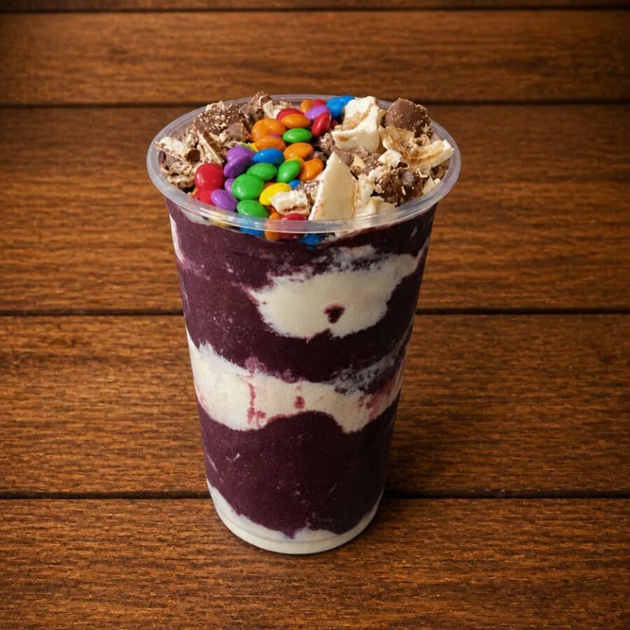Açaí super cremoso montado em camadas de leite em pó e leite condensado e no topo 5 adicionais de sua escolha