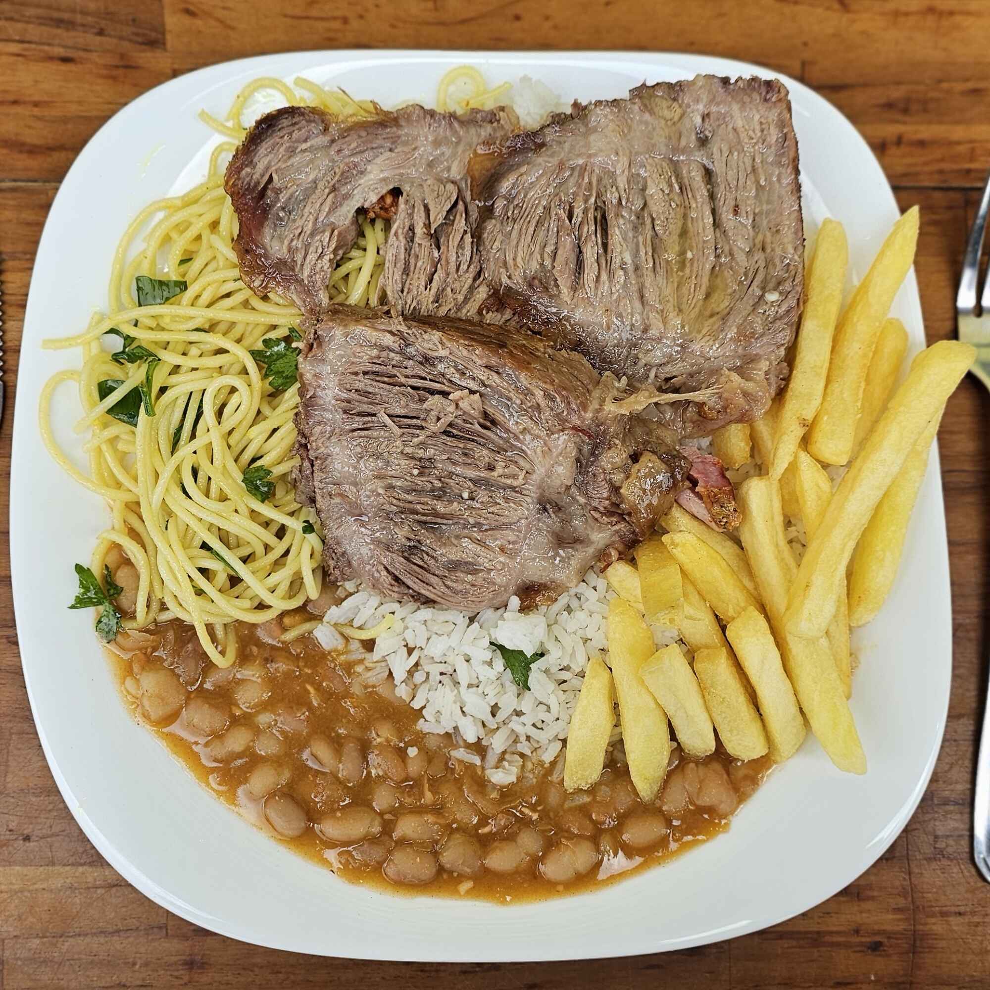Cupim assado no bafo com arroz branco, feijão, macarrão e batata frita.