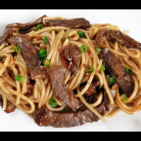 Espaguete com uma porção generosa de alcatra acebolada em tiras. Servido na marmita P