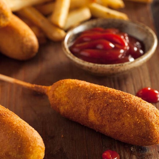 Corn dog con papas sazonadas.