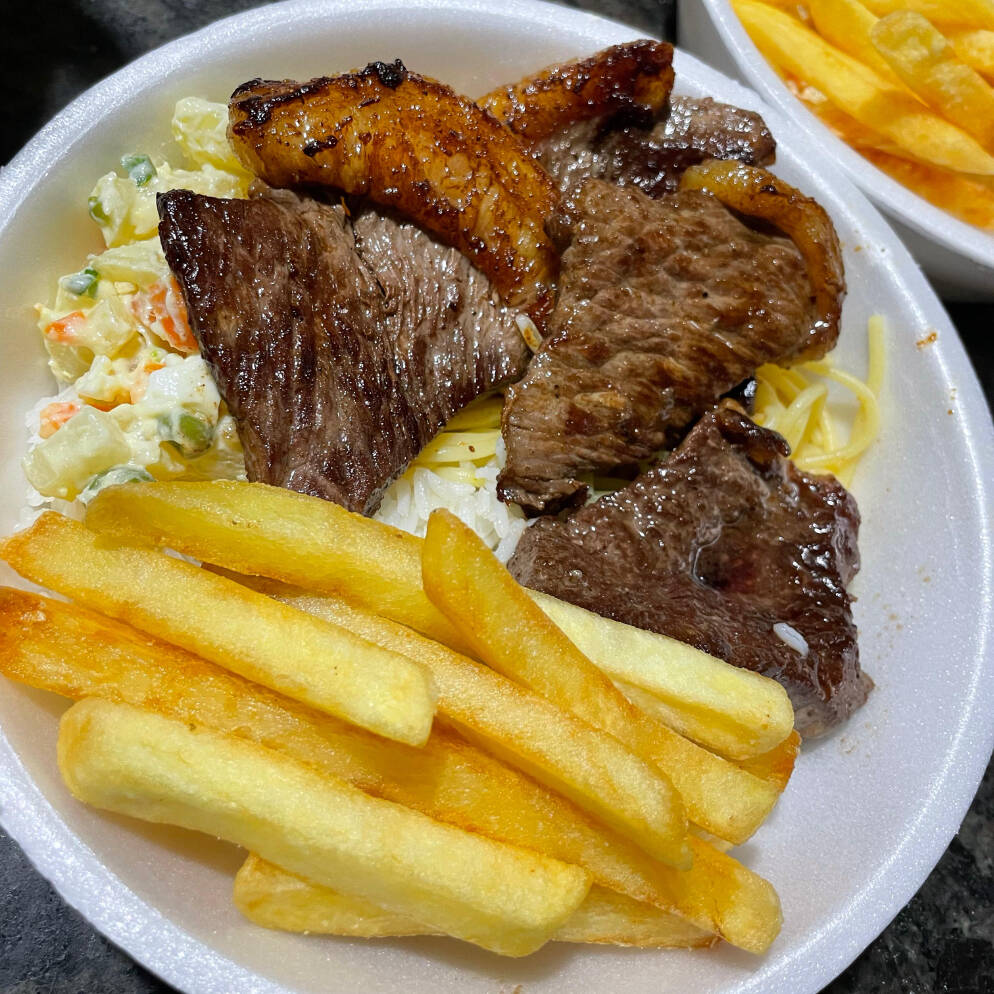 Alcatra na chapa com fritas. Acompanha arroz, feijão, salada, macarrão e a farofinha.