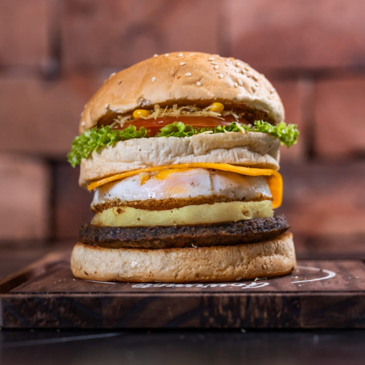 Pão, carne bovina, ovo, queijo prato, abacaxi, milho verde, batata palha, alface e tomate