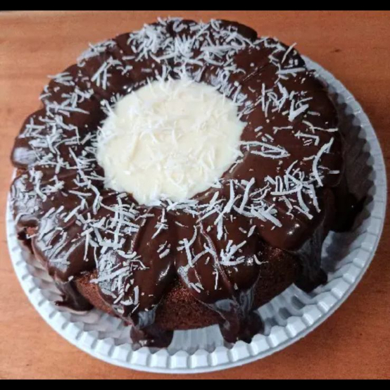 bolo de chocolate com o furo cheio de recheio de prestigio e cobertura de brigadeiro
