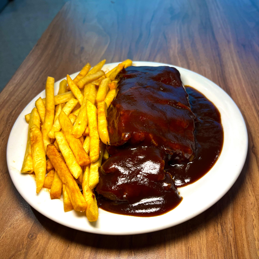 O prato-chefe do Raf’s: costelinha suína macia e suculenta, envolvida em molho barbecue e acompanhada de batata frita crocante. Outros acompanhamentos podem ser adicionados à parte.