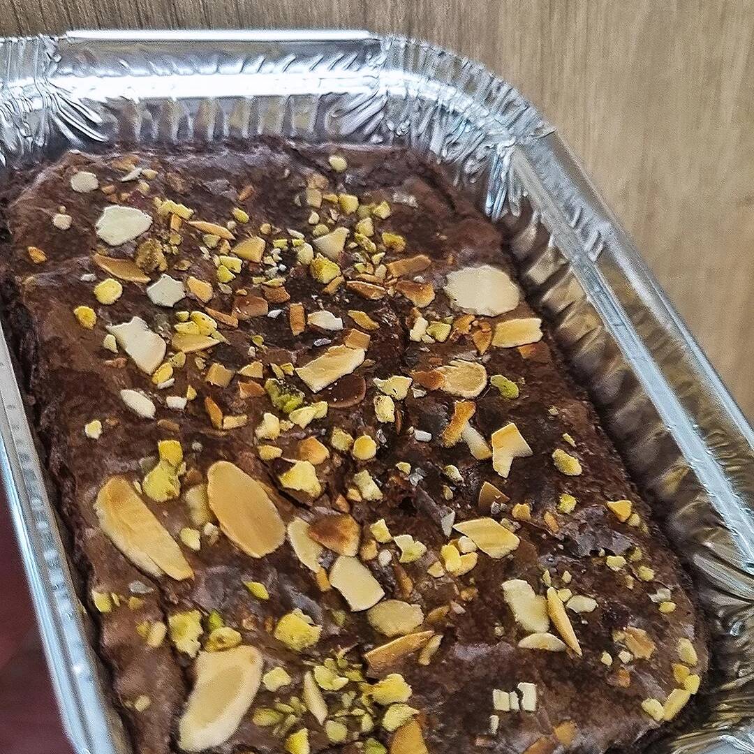Marmitinha de brownie 100g: nosso brownie tradicional sem cobertura, agora em uma versão especial com pistache e lâminas de amêndoas. Uma combinação equilibrada entre o sabor intenso do chocolate e o toque crocante das castanhas.