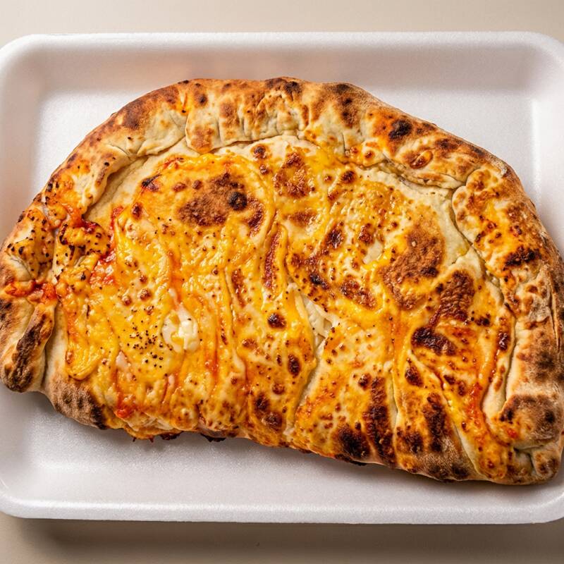 A 'Fogazza de Palmito com Mussarela' é uma deliciosa explosão de sabores. Preparada com um recheio generoso de palmito suculento e mussarela derretida, esta fogazza tem um sabor inigualável. O palmito é cuidadosamente selecionado e cozido à perfeição, enquanto a mussarela de alta qualidade se funde com ele, criando uma combinação irresistível.