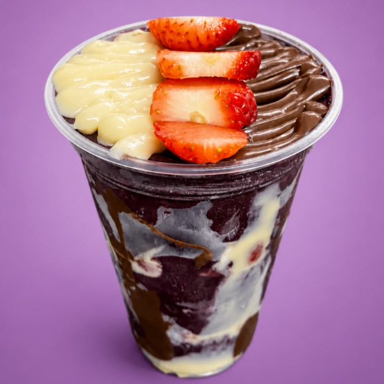 Açaí composto com camadas intercaladas de creme de Ninho, pedaços de morango e Nutella. (Copo montado, sem adição de complementos).