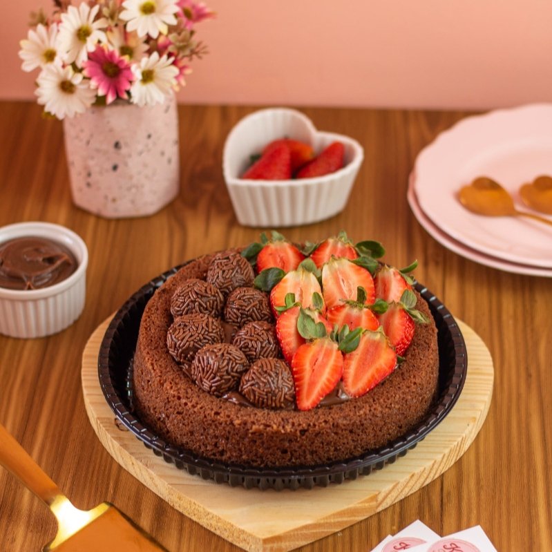Nossos bolos caseiros têm 19 cm de diâmetro, maior que os de padaria e um pouco menores que os feitos em casa. Servem de 6 a 8 fatias, ideal para até 6 pessoas. Bolo "Paraíso a sobremesa que renova sua alegria! Delicie-se com uma massa de chocolate fofinha, cobertura rica de 50% cacau, frescos morangos e brigadeiro feito na hora. Um pedacinho do céu em cada fatia! 🍰✨